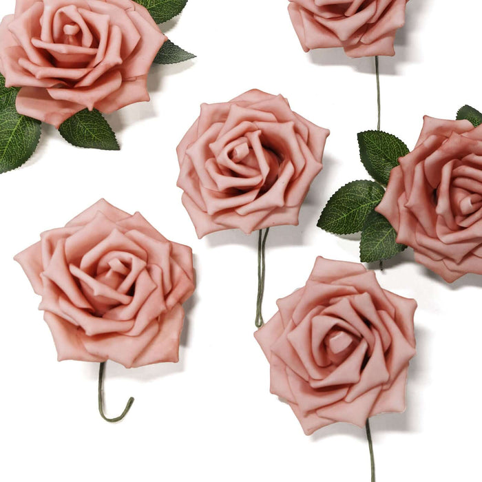 Pink artificial roses with green leaves on a white background