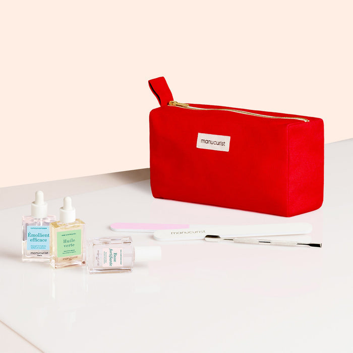 The Manucurist Complete Nail Care Kit includes a red zippered pouch on a white surface with three nail care bottles, a cuticle softener, nail file, and metal cuticle tool for easy nail prep.