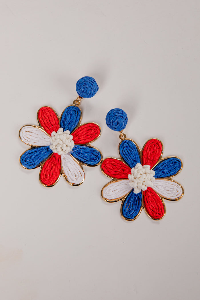 Flower-shaped earrings with red, white, and blue colors on a light gray background