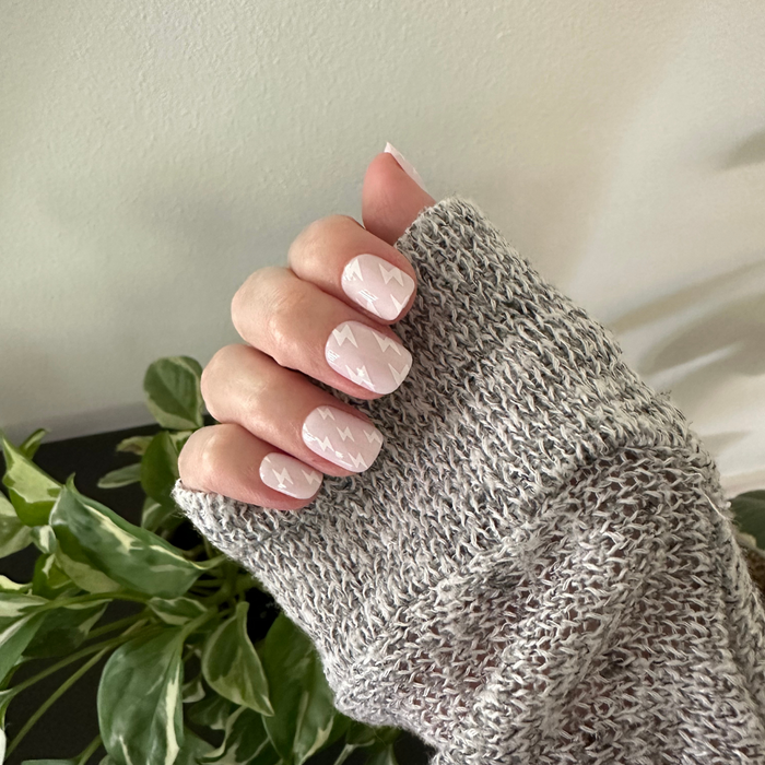 Lightning Strike | Extra Short | Squoval - Tab Press-On neutral mani with subtle white lightning bolt pattern on hand in cozy gray sweater