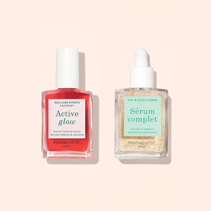 Two clear glass bottles with white caps on a beige background. Left: red liquid, Active Glow. Right: Nail Hydrating Serum by Manucurist with dropper—a nail care duo to repair and hydrate damaged nails.