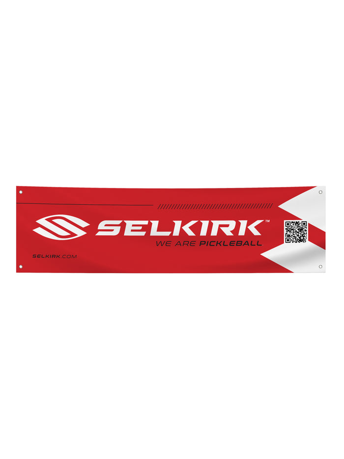 Red vinyl court banner with SELKIRK TM logo, text 'WE ARE PICKLEBALL', 'SELKIRK.COM' and a QR code