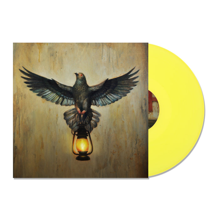 A yellow vinyl record slides from its cover, featuring a pigeon with wings spread on a lit lantern against an earthy backdropโthe perfect display piece for your Silverstein collection.