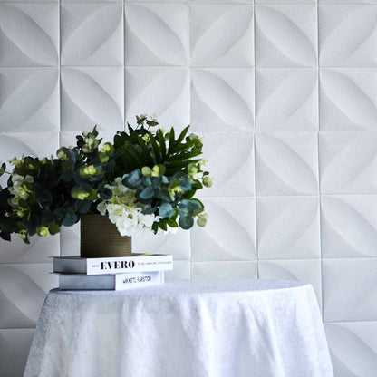 Decorative wall tiles with 3D texture and potted plants on a table.