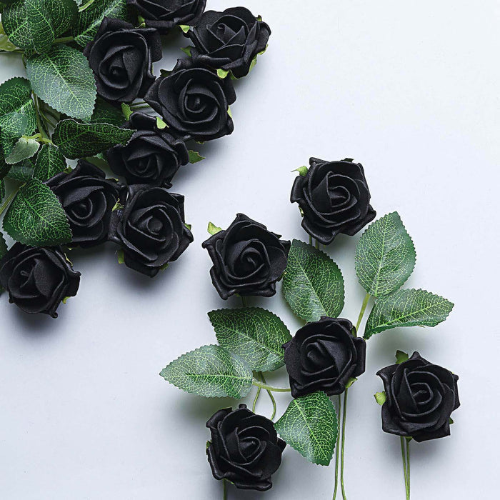 Black artificial roses with green leaves on a light background.