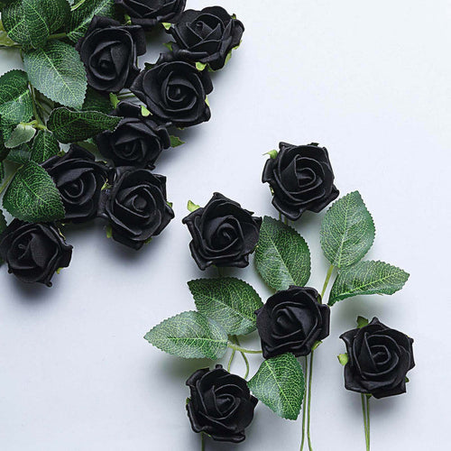 Black artificial roses with green leaves on a light background.