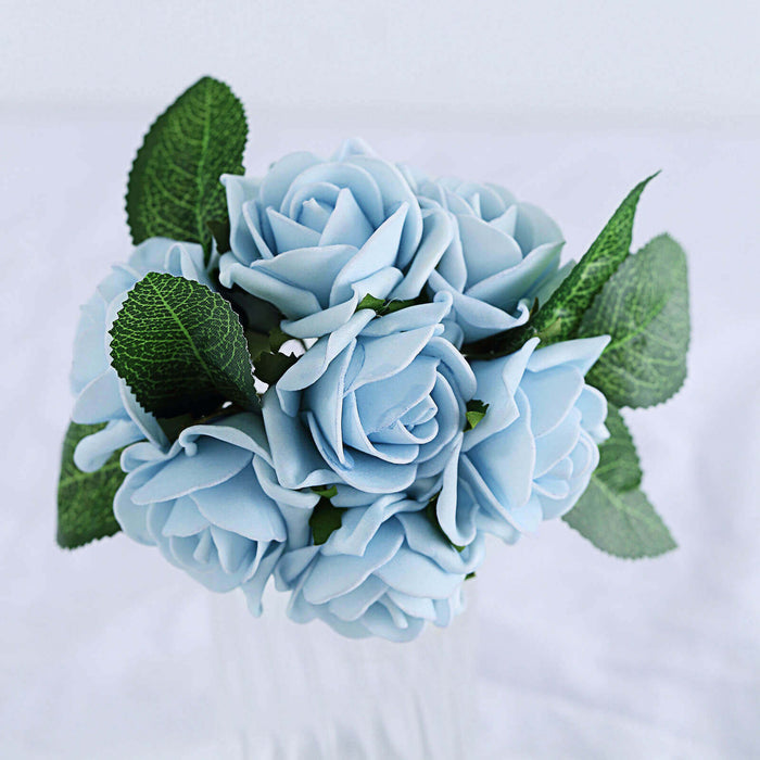 Blue rose bouquet with green leaves in a clear vase.