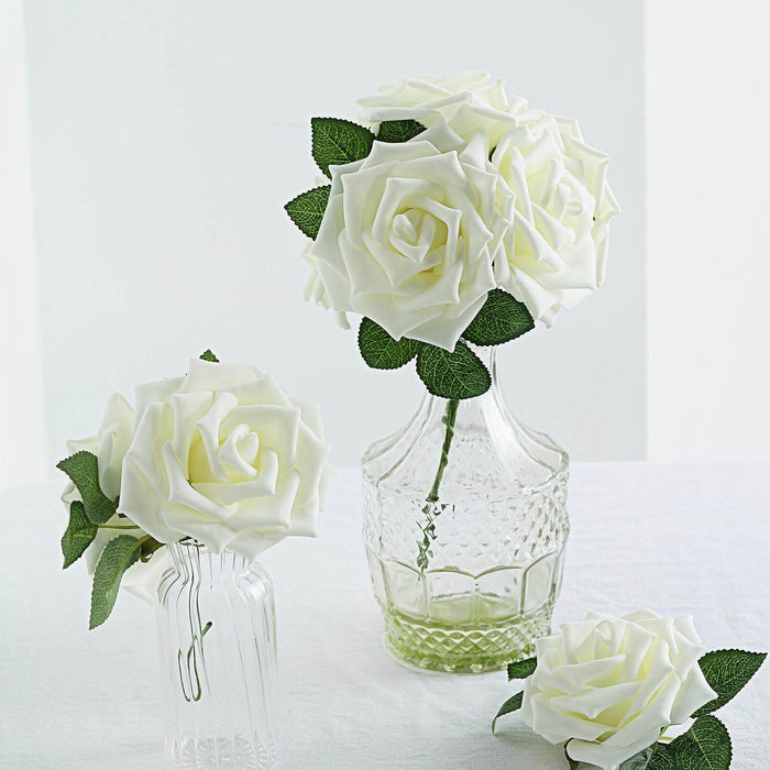 White artificial roses in glass vases on a light background