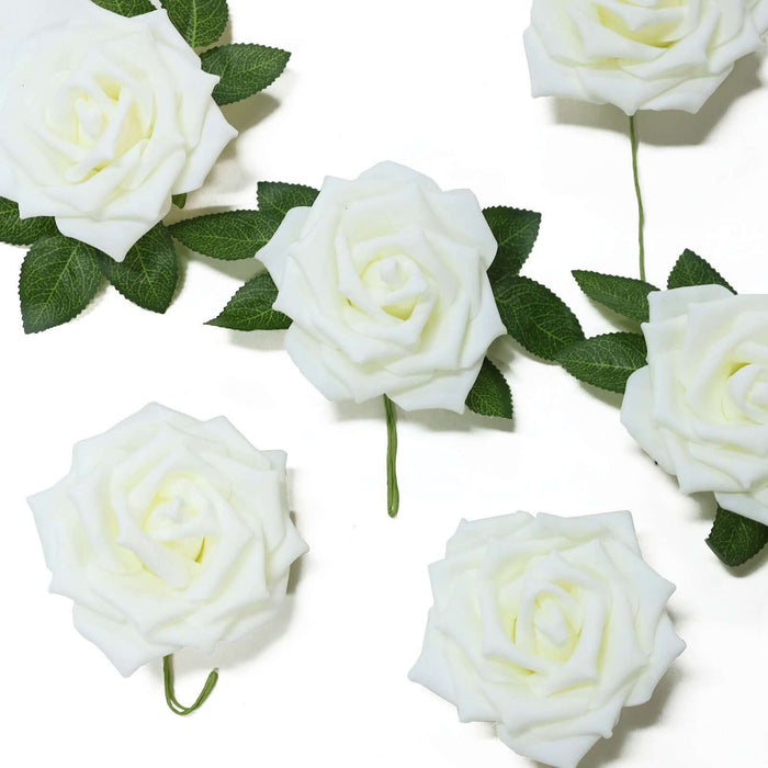 White artificial roses with green leaves on a white background.