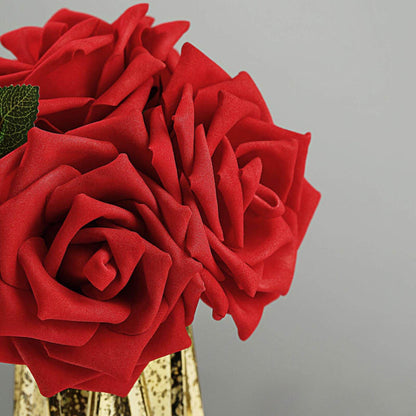 Red artificial roses in a decorative gold vase.