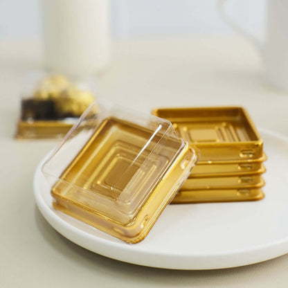 Gold square coasters stacked on a plate with a blurred background.