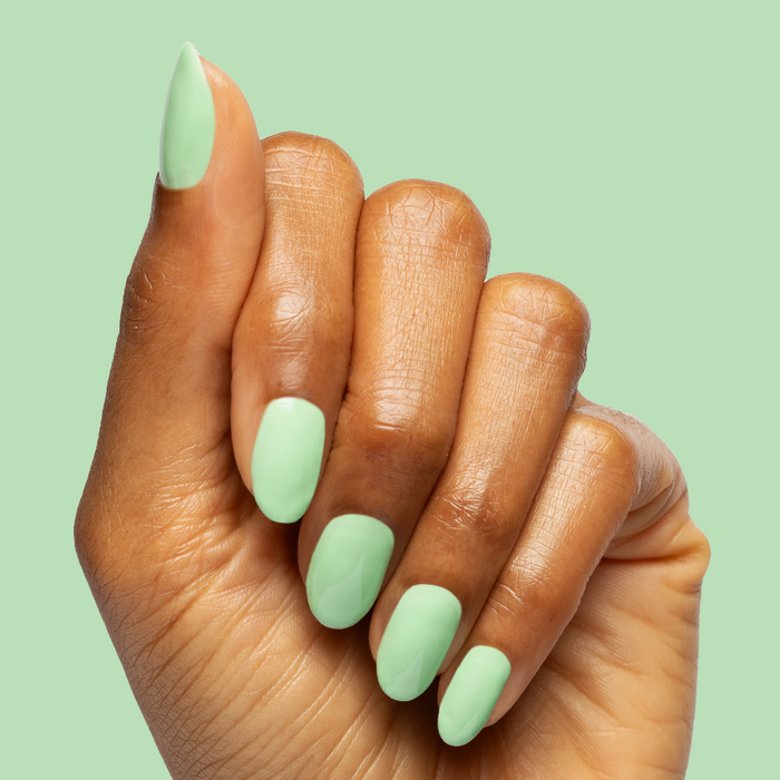 Hand with nails polished in pastel green using Aced It - Gel for a smooth, long-lasting at home mani look