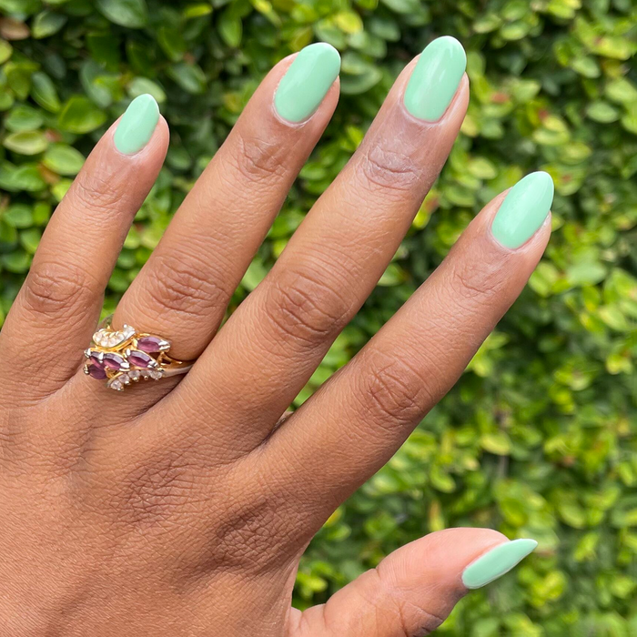 Hand with nails painted in a cool pastel green using Aced It - Gel for a smooth, long-lasting manicure at home