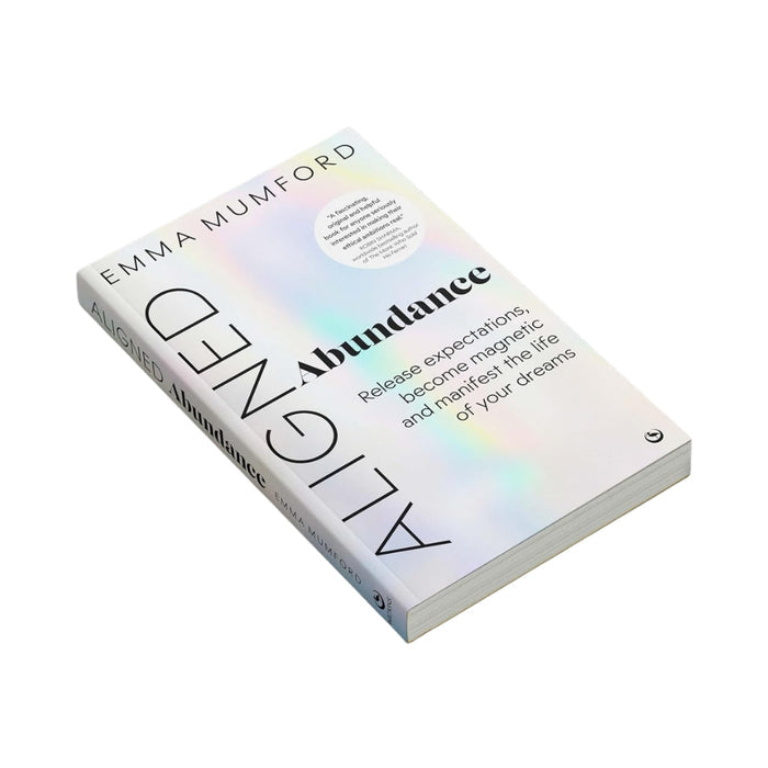 A book titled 'Aligned: Abundance' by Emma Mumford, featuring a white cover with an iridescent pastel rainbow sheen and black typography, shown on a plain white background.