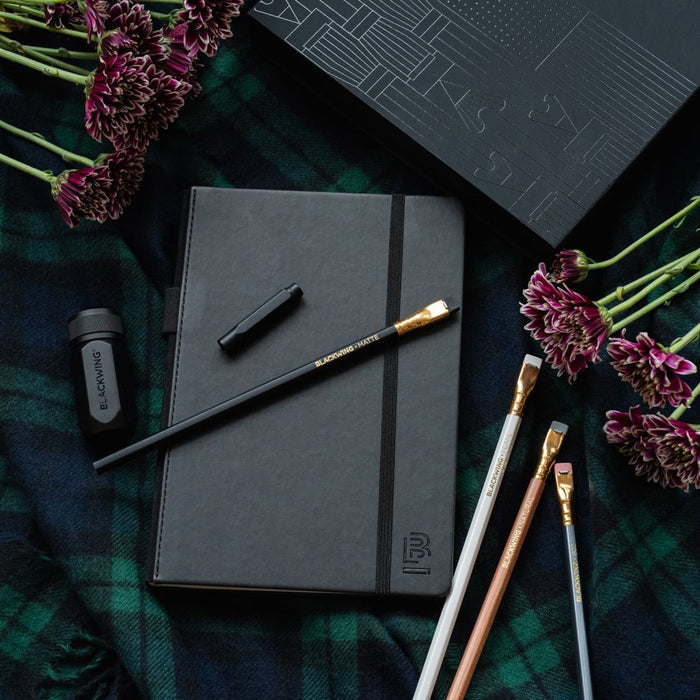 Blackwing Notebook Essentials Set includes a black slate notebook, 4 core pencils, a black pencil point protector, and a black one-step sharpener