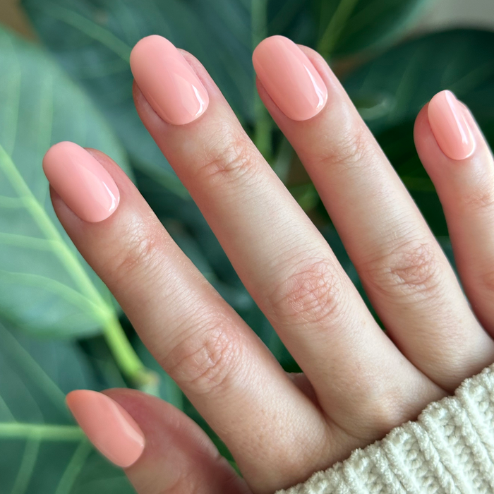 Hand with nails featuring Carnation | Short | Round - Tab Press-On in soft floral pink for an easy at-home mani