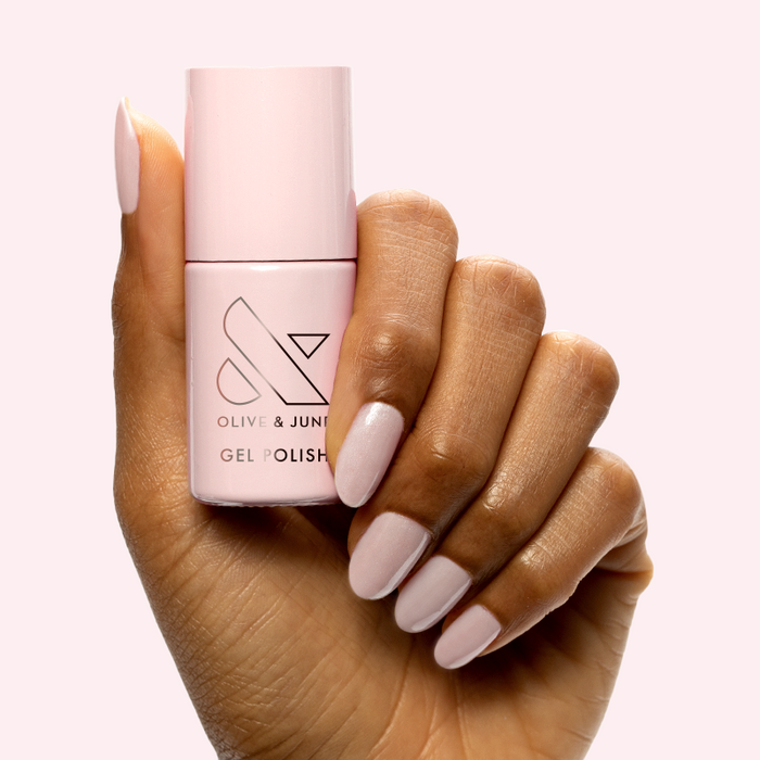 CCT - Gel bottle held by hand with soft sheer pink gel polish for a feminine and delicate manicure by Olive and June