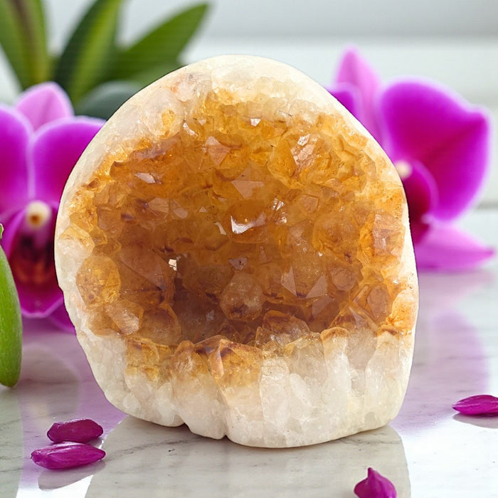 Geode crystal with a pink orchid in the background