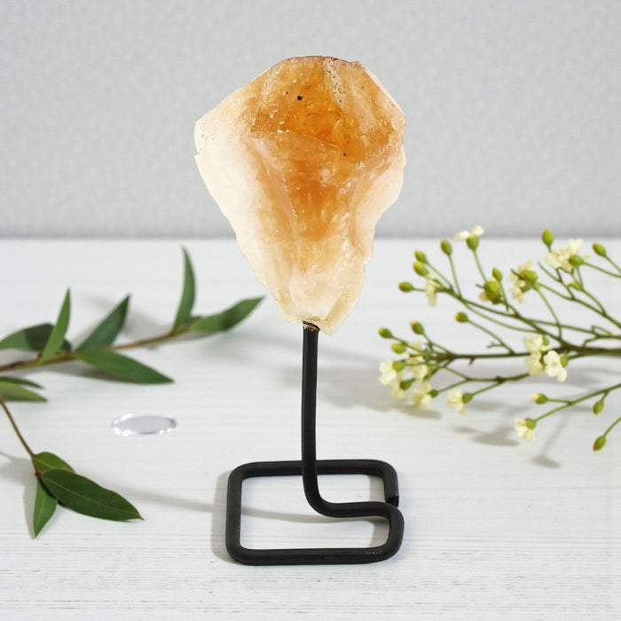 Decorative crystal on a stand with greenery on a light background