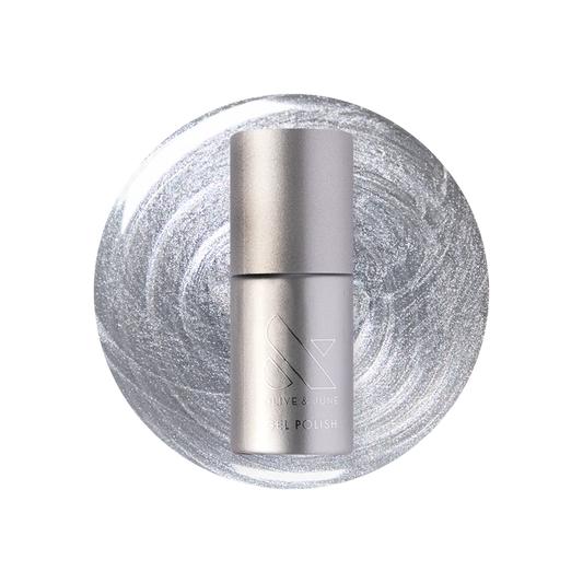 Cosmic Silver - Gel bottle shown on a metallic silver polish background for a long-lasting mani by Olive and June