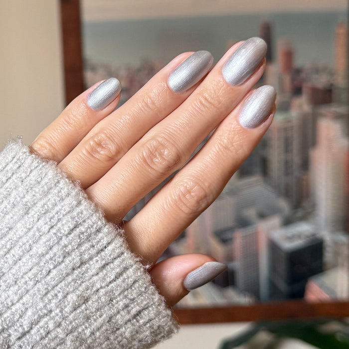 Cosmic Silver - Gel metallic silver gel polish manicure on medium almond-shaped nails with a soft sweater sleeve by Olive and June