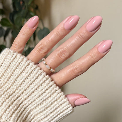 HZ - Gel manicure on almond-shaped nails in a soft rosy neutral shade with a cozy cream sweater background