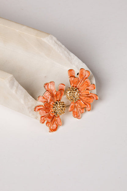 Floral earrings with gold centers on a light background