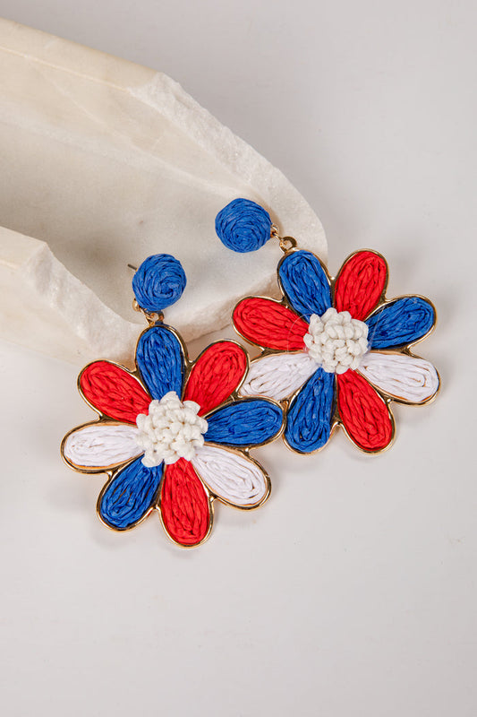 Flower-shaped earrings with red, white, and blue design on a light background