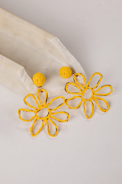 Yellow flower-shaped earrings on a light gray background