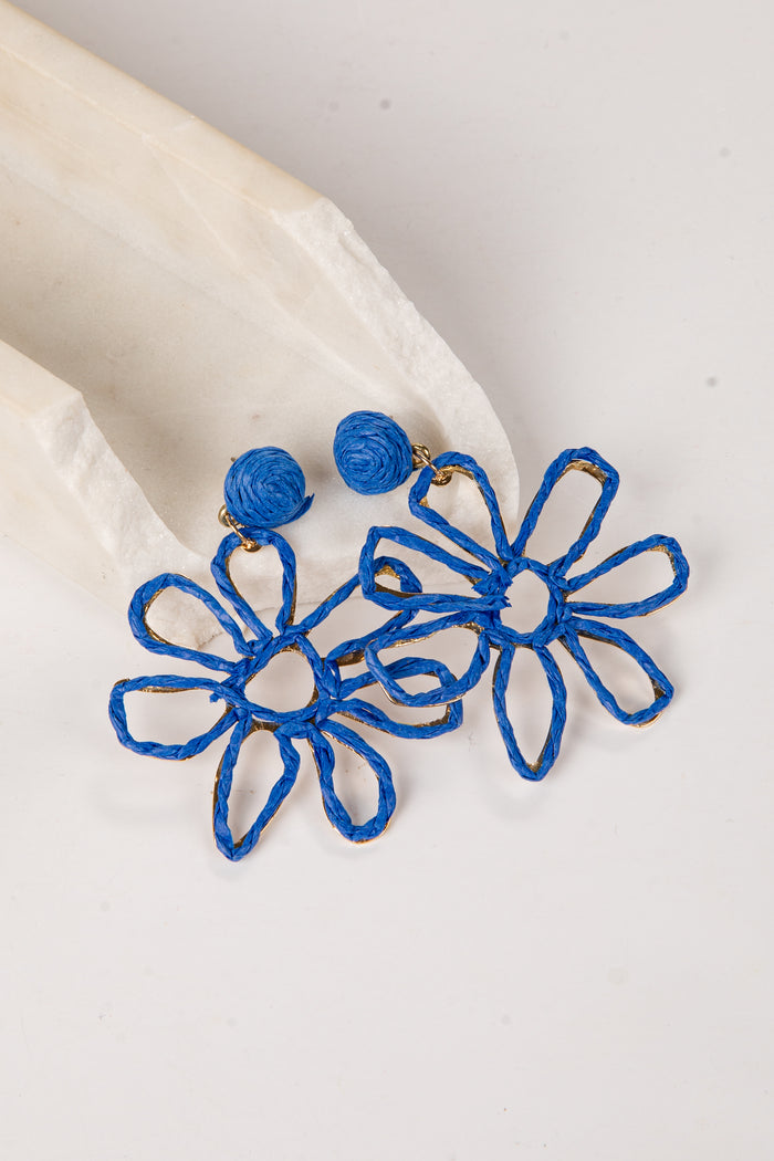Blue flower-shaped earrings on a light background
