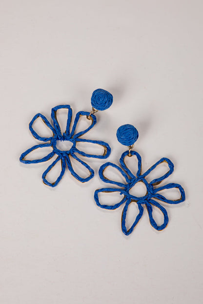 Blue flower-shaped earrings on a light gray background
