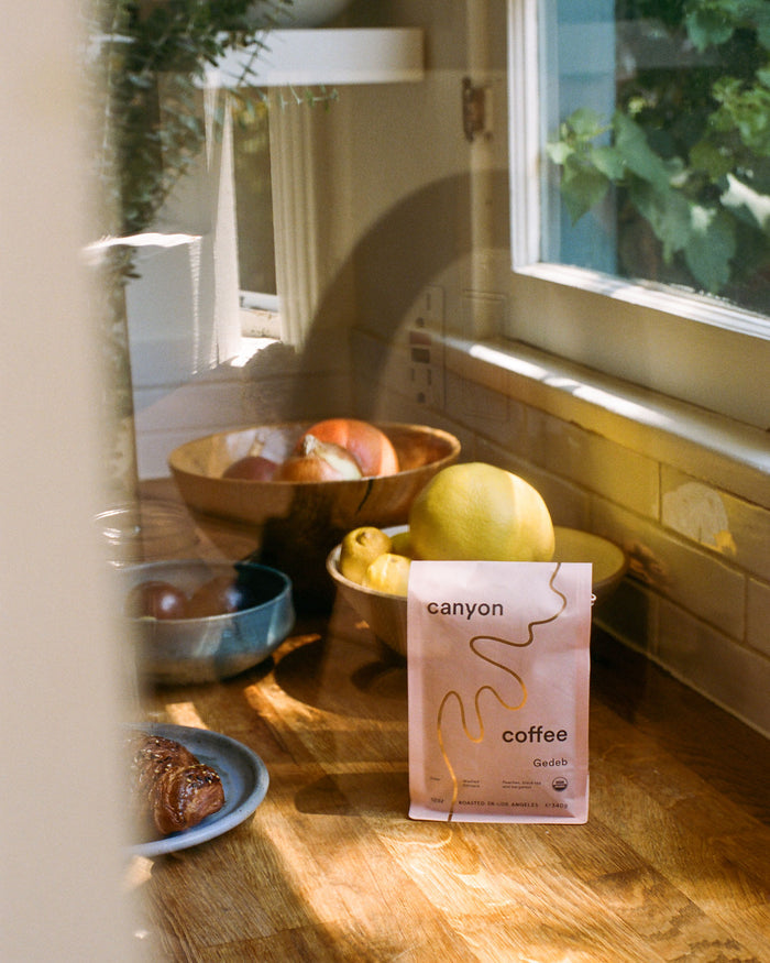 A bag of Gedeb Whole Bean coffee by Canyon Coffee with gold foil