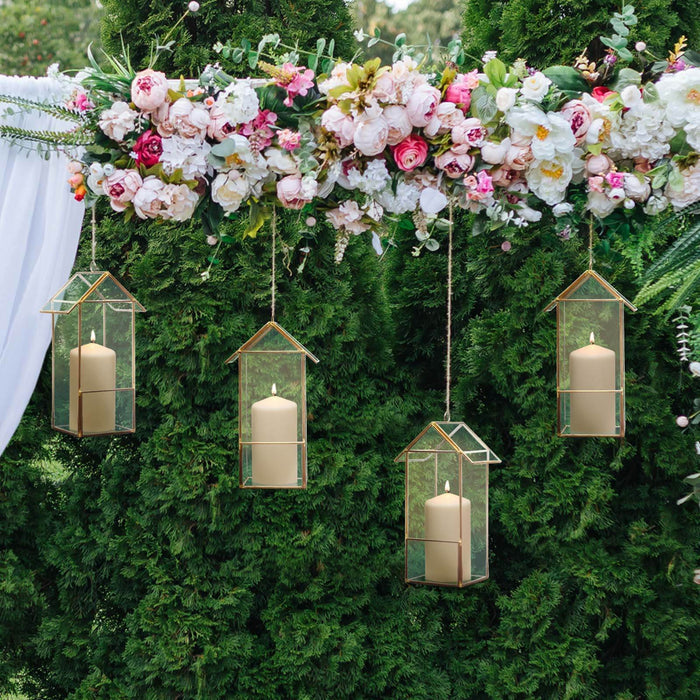 Hanging candle holders with flowers in a decorative outdoor setting.