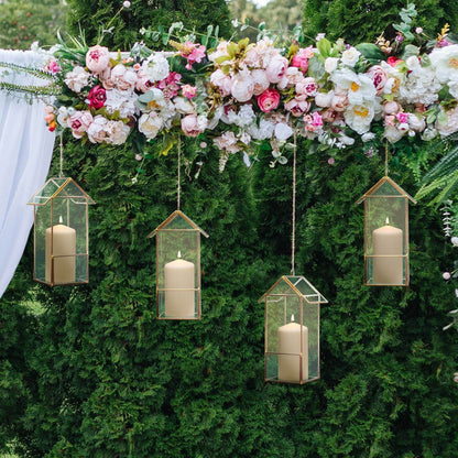 Hanging candle holders with flowers in a decorative outdoor setting.