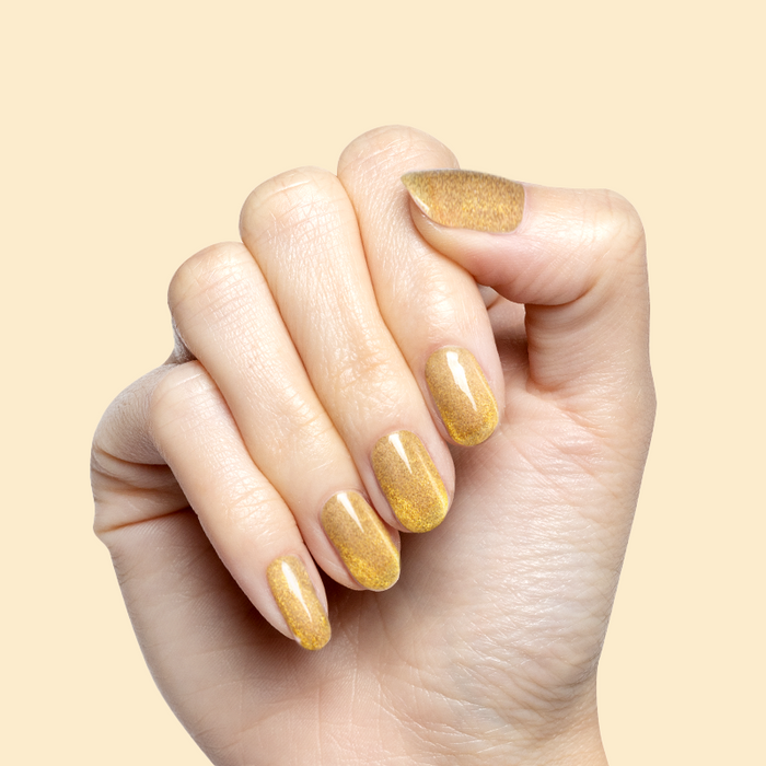 Hand with nails painted in Golden Velvet - Gel showing sheer golden bronze sheen manicure with magnetic polish effect