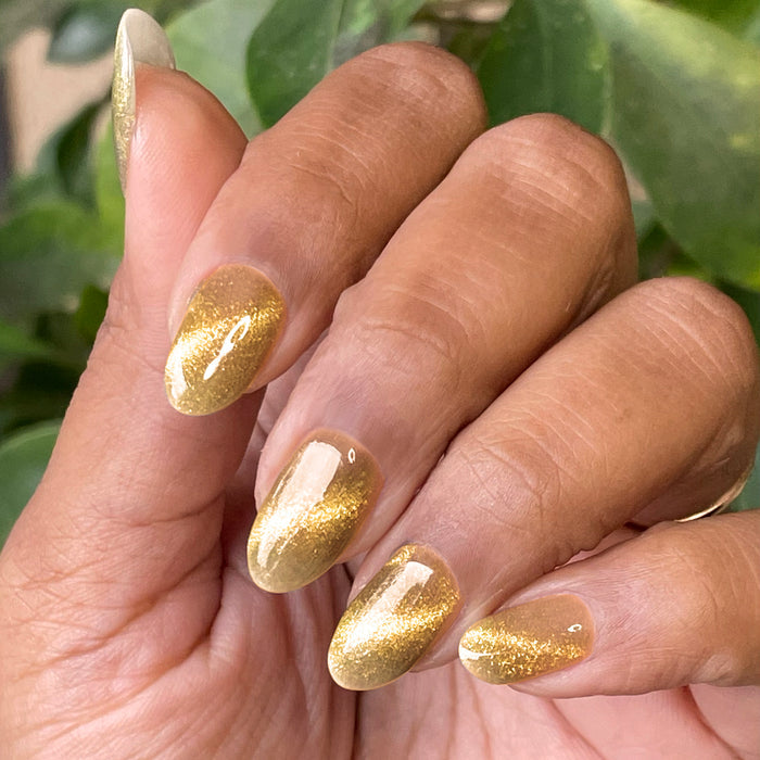 Close-up of hand with nails painted in Golden Velvet - Gel showing sheer golden bronze metallic manicure effect