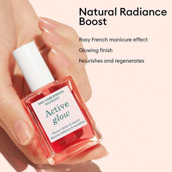 A hand holds a bottle of Manucurist’s Healthy Glow Duo, with benefits—rosy French manicure effect, glowing finish, nourishes like a nail serum, and regenerates—listed beside it on a light pink background.