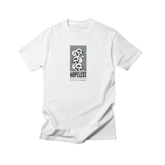 A white Comfort Colors t-shirt from Hopeless Records featuring a modern black and white graphic of three dinosaur skulls stacked above HOPELESS thirty years. Minimalist design—ideal for unique apparel enthusiasts.