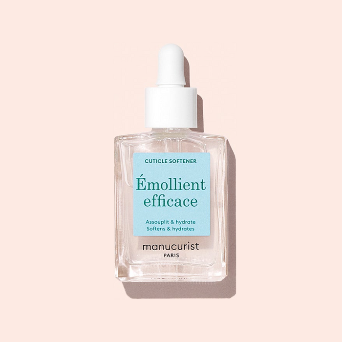A clear glass dropper bottle of Manucurist Hydrating Cuticle Softener, featuring a white dropper cap and set against a light pink background—the perfect addition to your manicure routine.
