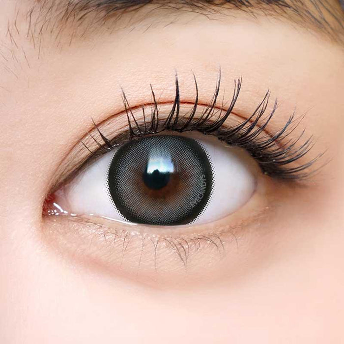 Close-up shot of a model with natural dark eyes wearing Dekame Love Me Grey contact lenses, complemented by natural eye make up.