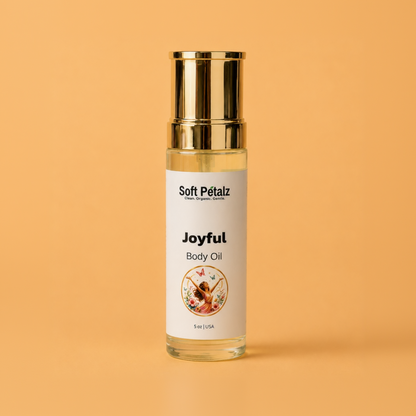 Body oil bottle labeled 'Joyful' by Soft Pétalz on a peach background