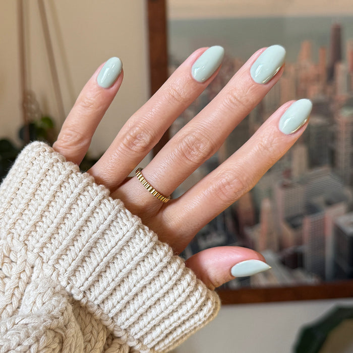 KMC - Gel displayed on hand with soft pastel green nails, showcasing a smooth, long-lasting gel polish manicure by Olive and June