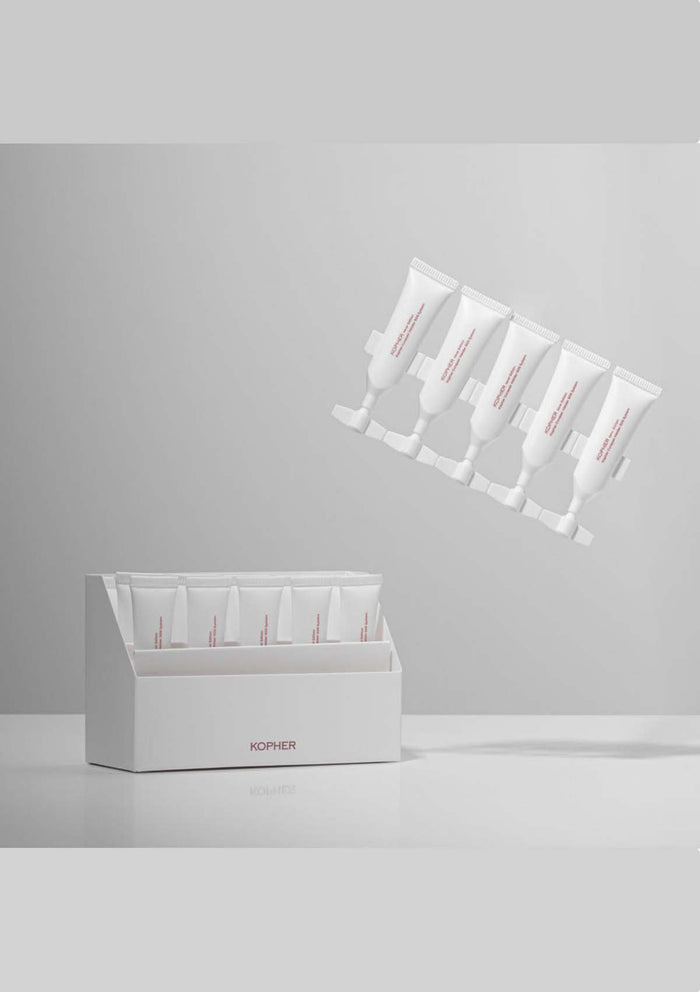 White skincare product packaging with multiple tubes on a gray background