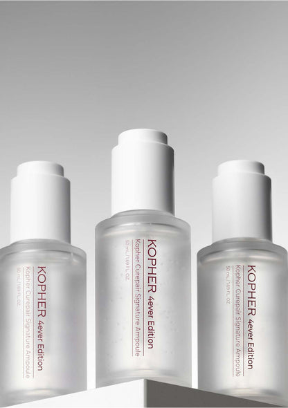 Three Kopher skincare bottles on a gray background