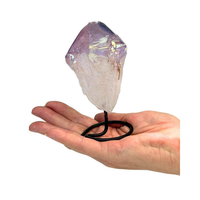Crystal with a black cord held in a hand on a white background