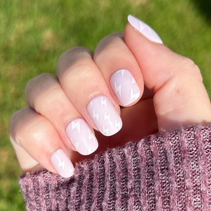 Lightning Strike | Extra Short | Squoval - Tab Press-On neutral mani with white micro lightning bolts on hand against outdoor background