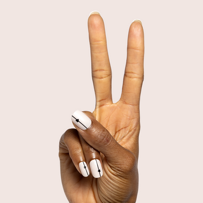 Linear Hearts | Short | Squoval - Tab Press-On white press-on nails with black linear hearts on fingers making peace sign