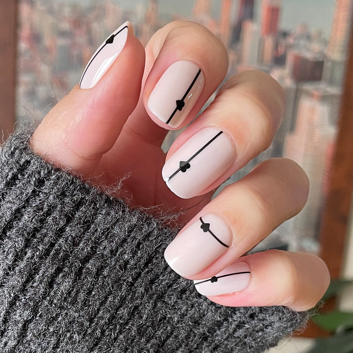 Linear Hearts | Short | Squoval - Tab Press-On neutral nails with thin black lines and tiny heart accents on hand in gray knit sleeve