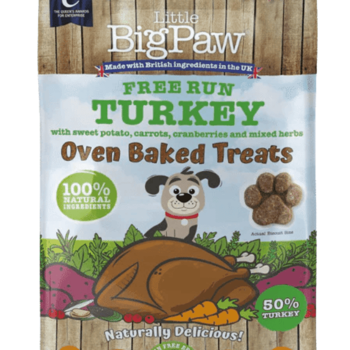 White background with a close up of a packet of Little BigPaw 'Free Run Turkey with sweet potato, carrots, cranberries and mixed herbs' dog treats. Pictured on the packet is an illustration of a grey dog with a cooked turkey and vegetables in the foreground. Text on the bag says 'Oven Baked Treats, 100% natural ingredients, Naturally delicious! 50% turkey'.