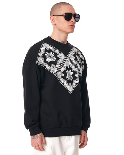 Martin Valen men's oversized black sweatshirt, three-quarter view showing white ethnic V-shaped print across the chest